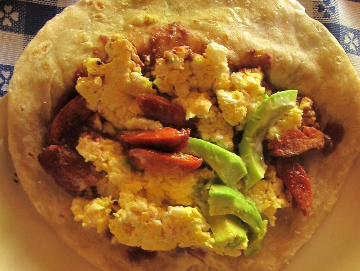 Baleada hondureña abierta con frijoles, huevo revuelto, aguacate y chorizo