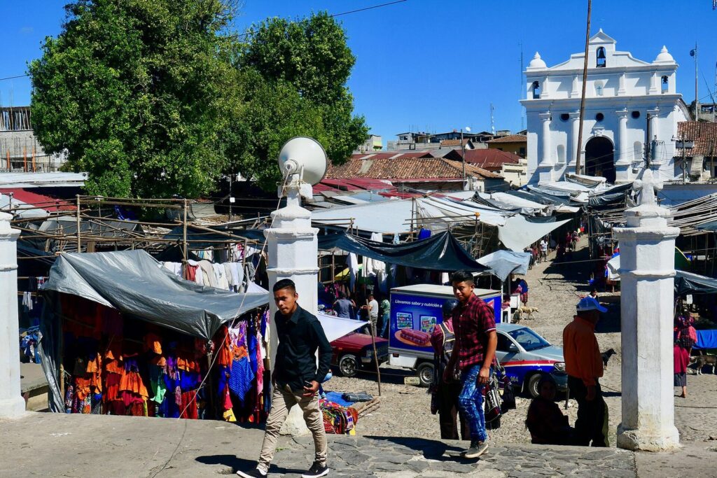 Vista general de los toldos del mercado de Chichicastenango con la iglesia blanca al fondo