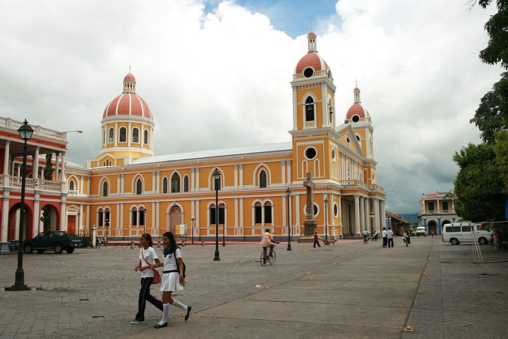 Plaza de Granada frente a la catedral amarilla con gente paseando
