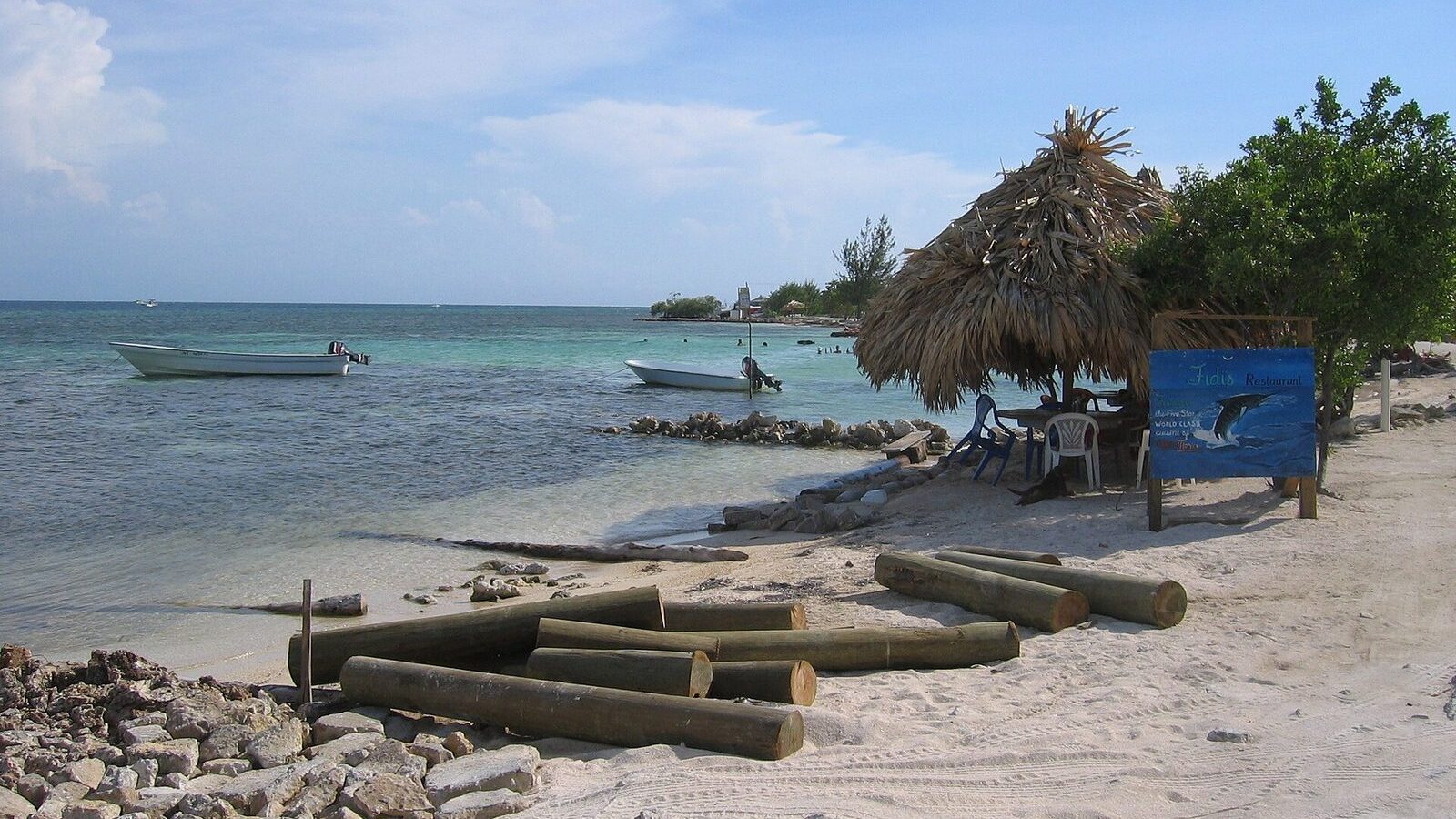 Playa caribeña de Utila, en las Islas de la Bahía de Honduras, con barcas y palmeras