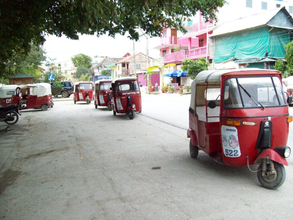 Tuk-tuks rojos aparcados en una calle de la isla de Flores, Guatemala