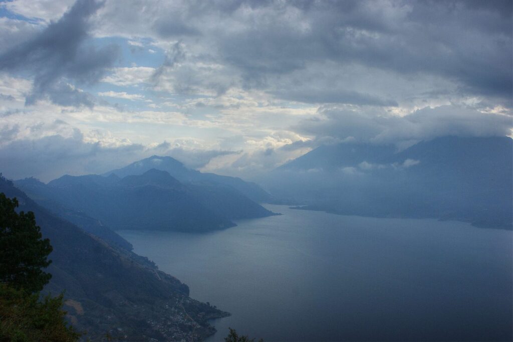 Aguas del lago Atitlán al amanecer con los volcanes recortados entre la bruma