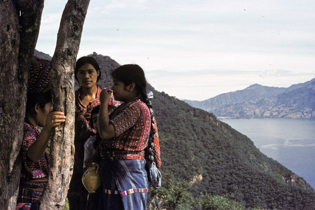 Tres mujeres mayas con huipiles tradicionales junto al lago Atitlán