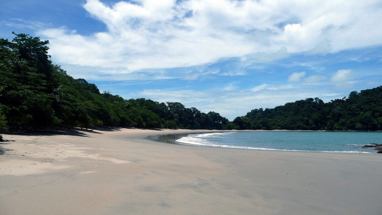 Playa de arena blanca del parque nacional Manuel Antonio bordeada de selva
