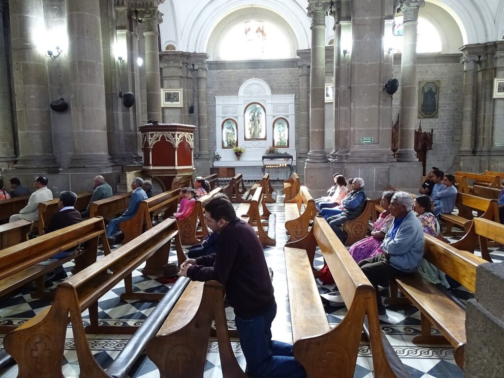 Fieles rezando en los bancos de la catedral de Quetzaltenango