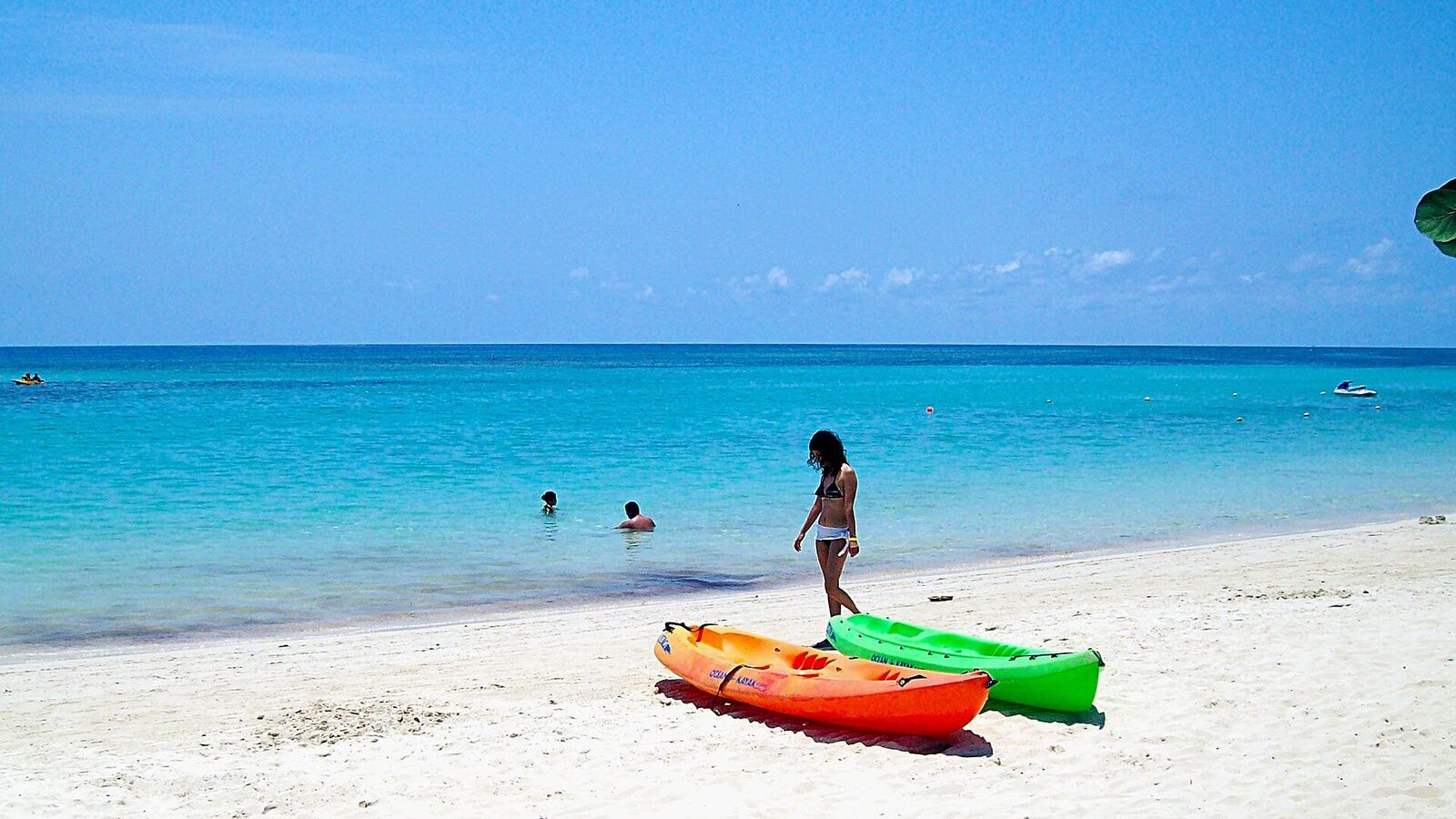 Playa de West Bay en Roatán con agua turquesa, kayaks de colores y arena blanca
