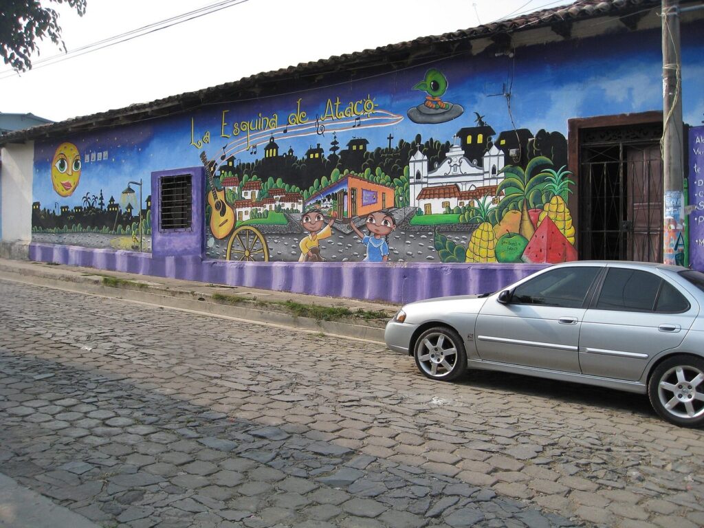 Calle empedrada de Ataco con casas pintadas con murales de paisajes