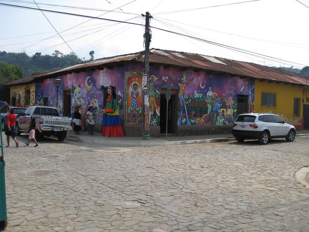 Fachada decorada con un mural de figuras tradicionales en la Ruta de las Flores
