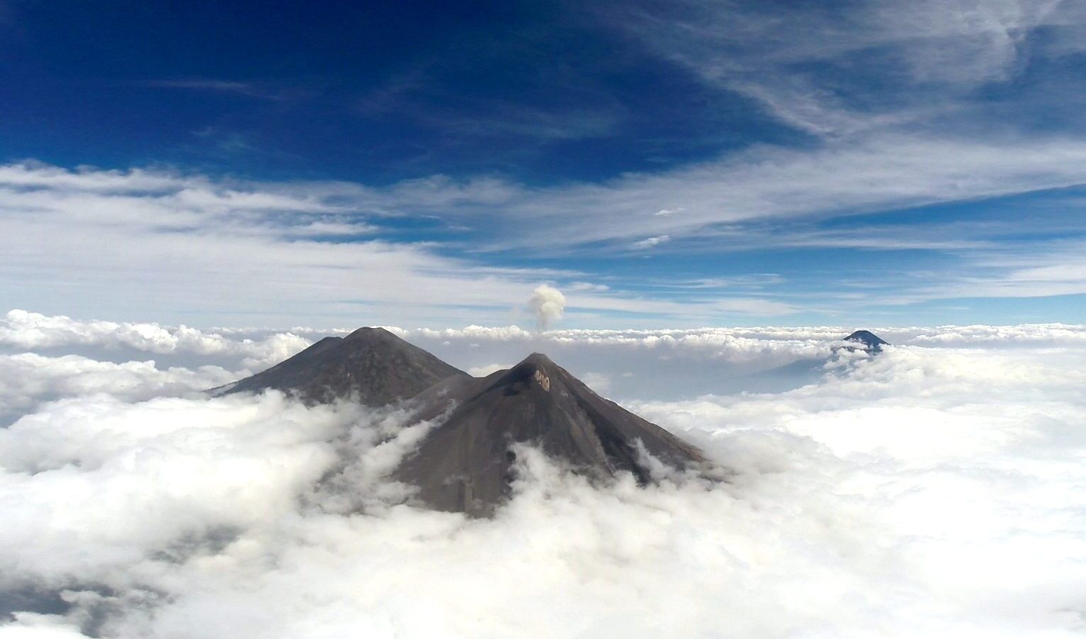 Cima del volcán Acatenango emergiendo sobre un mar de nubes al amanecer
