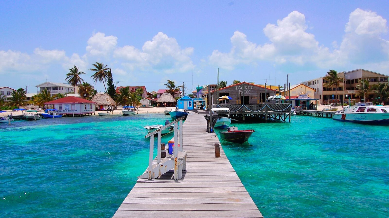 Muelle de madera adentrándose en el agua turquesa de Ambergris Caye