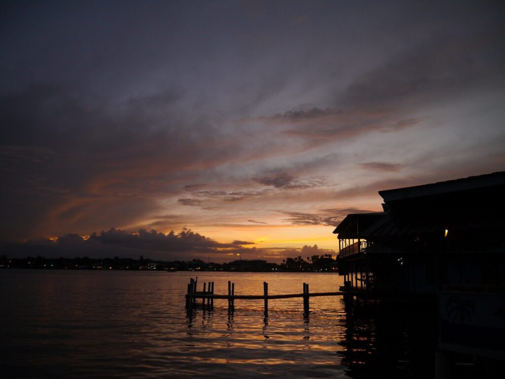 Atardecer sobre el agua con casas de madera sobre pilotes en Bocas del Toro