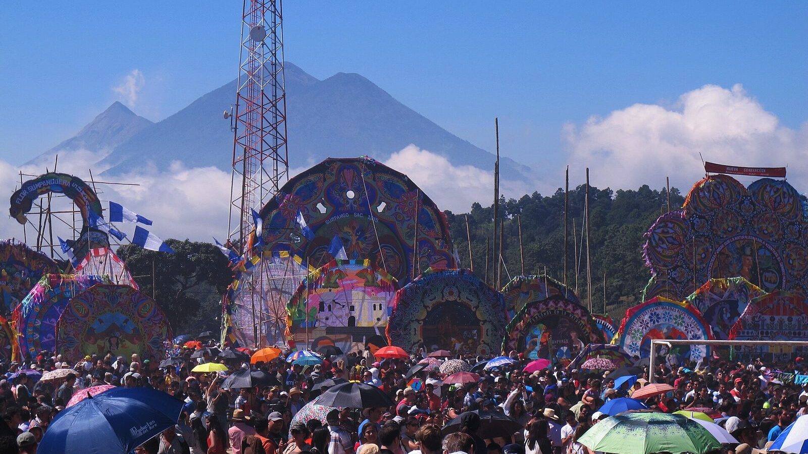 Barriletes gigantes de colores levantados sobre el público en Sumpango, Guatemala