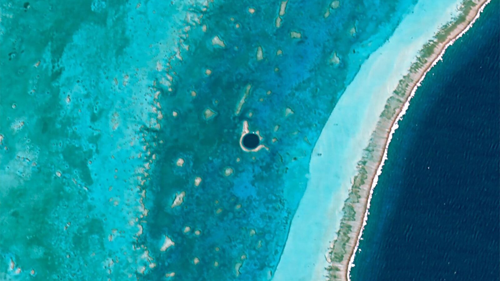 Vista aérea del Gran Agujero Azul de Belice, un círculo oscuro sobre el arrecife turquesa